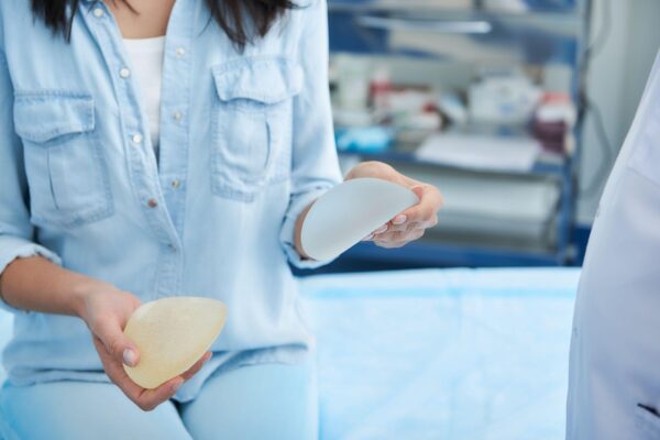 close up of woman holding different types of implants for breast augmentation in doctor office