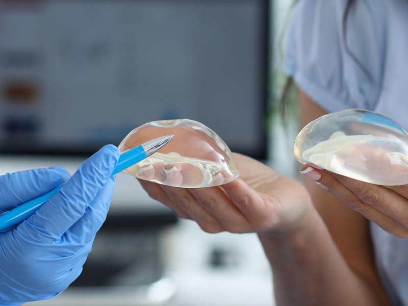 professional doctor explain difference between breast implants to client