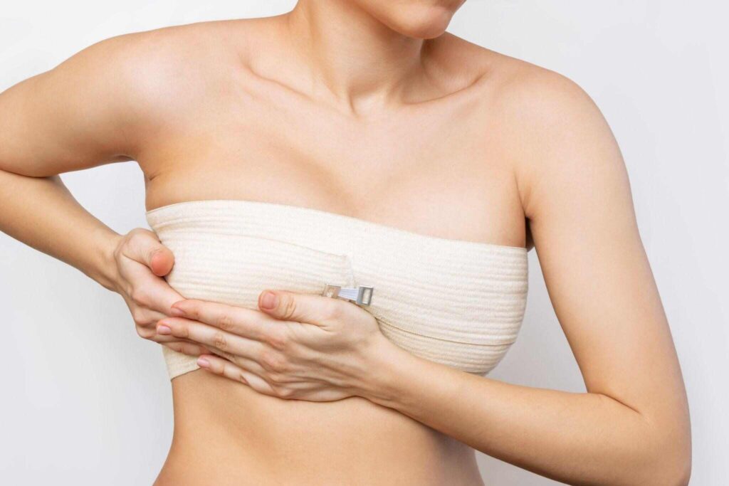 young woman with elastic bandage after breast augmentation
