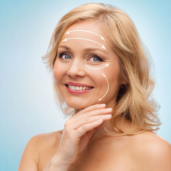 older blonde woman smiling with arrows depicting facelift guide