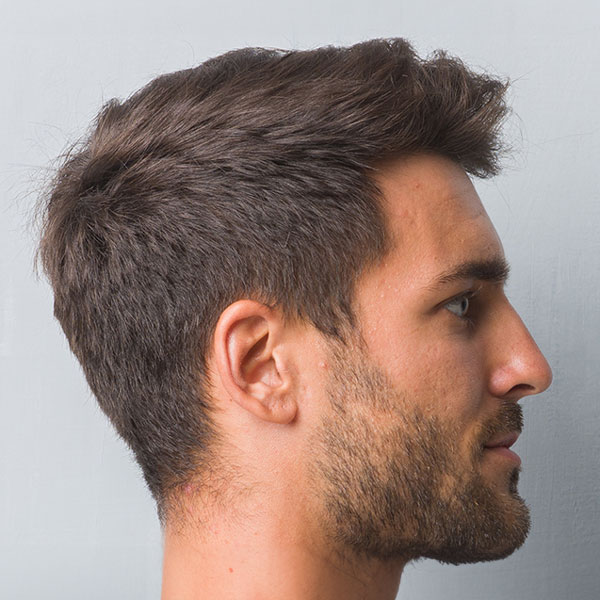 side profile of a man with a full head of hair and beard