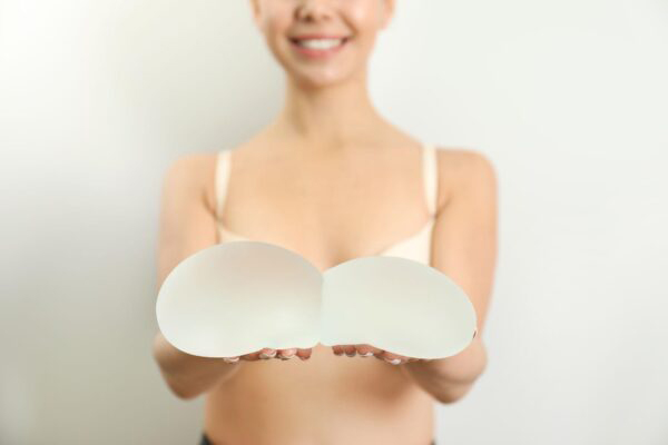 Woman holding silicone implants for breast augmentation